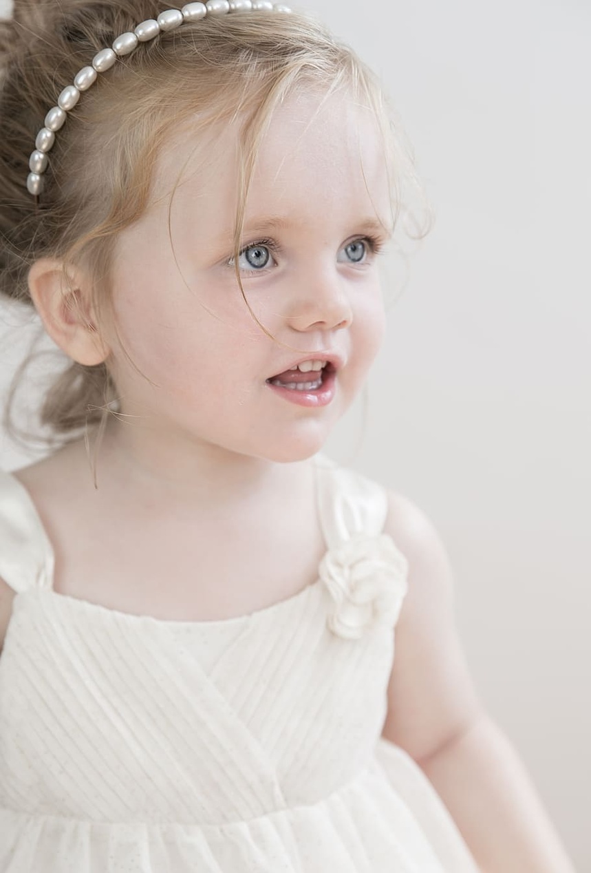 Ein junges Mädchen posiert selbstbewusst in modischer Kleidung für ein Foto.