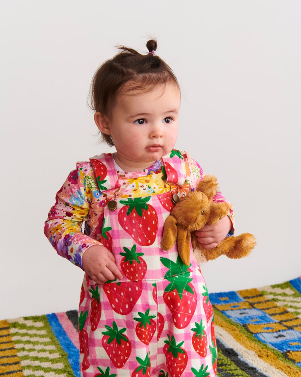 Eine Person sitzt vor einem Laptop und durchstöbert einen Online-Shop für Kinderkleidung.