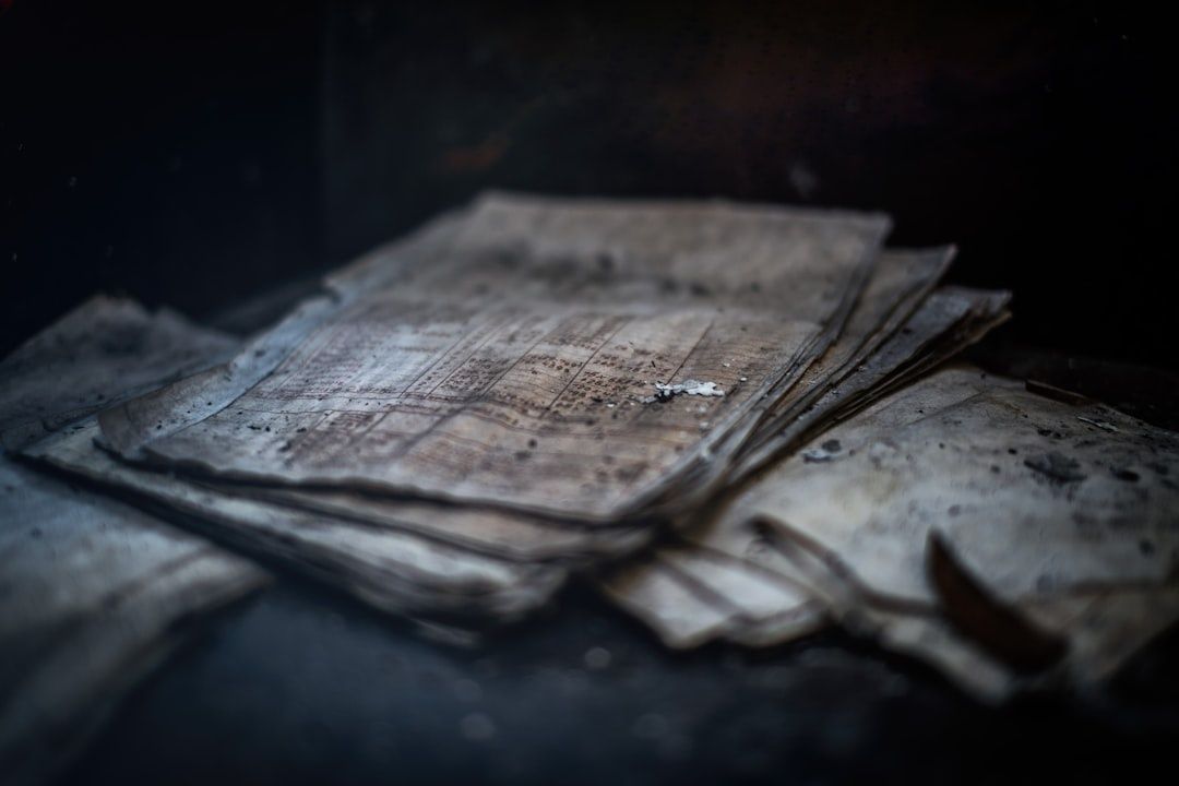 Stapel alter, verschmutzter Zeitungsseiten in dunkler Umgebung