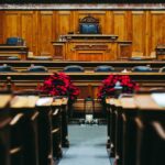 Leerer Sitzungssaal im Rathaus mit Rednerpult und roten Blumen