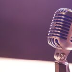 Klassisches Studiomikrofon vor violettem Hintergrund im weichen Licht