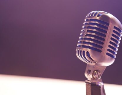 Klassisches Studiomikrofon vor violettem Hintergrund im weichen Licht