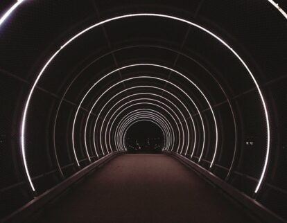 Dunkler Fußgängertunnel mit konzentrischen weißen Neonringen